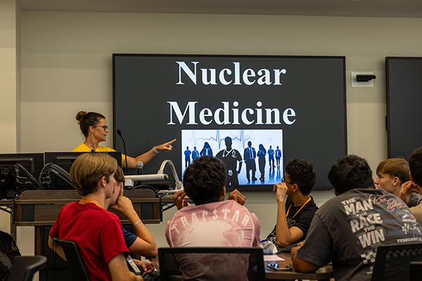 A teacher presents to a class about nuclear medicine